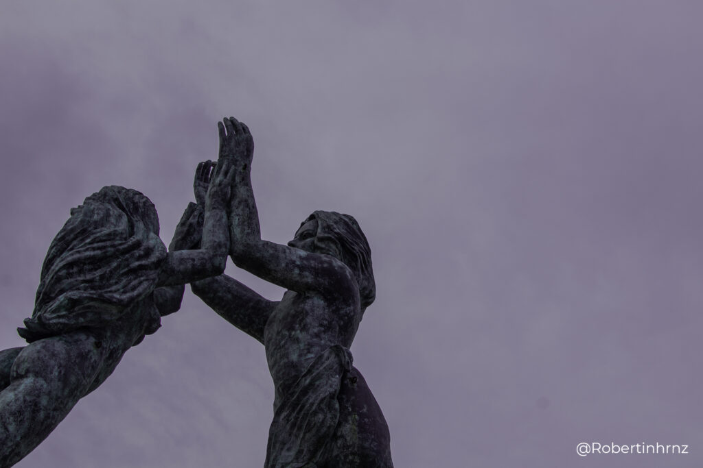 Escultura en Playa del Carmen de un hombre y mujer levantando las manos.