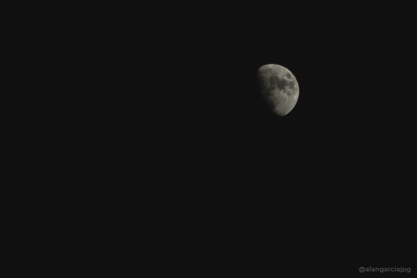 Luna creciente en cielo nocturno despejado.